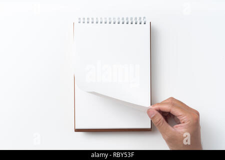 Designkonzept - Perspektivische Ansicht braun hardcover Spirale notebook, Hand des Menschen flip curl Seite auf Hintergrund für Mockup isoliert Stockfoto