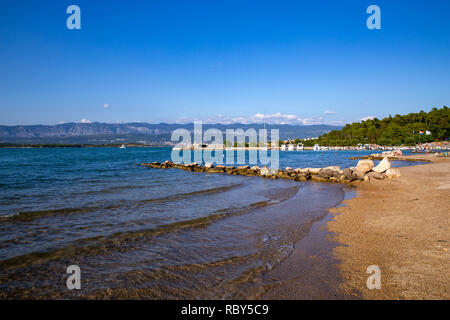 Strand mit Blick auf die Bucht Soline mit der Dinarischen Alpen im Hintergrund von Soline auf der Insel Krk, Kroatien gesehen Stockfoto