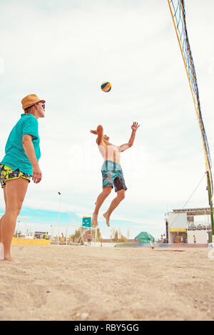 Volleyball beach Player ist ein Athlet Volleyball Spieler fertig, den Ball am Strand zu dienen. Stockfoto
