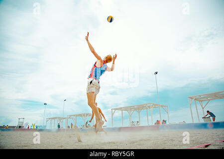 Volleyball beach Player ist ein Athlet Volleyball Spieler fertig, den Ball am Strand zu dienen. Stockfoto