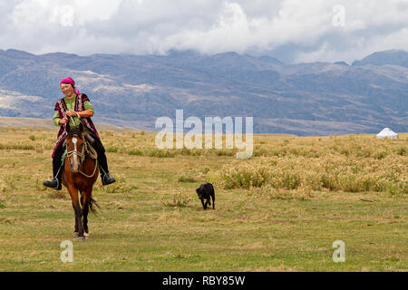 Nomadische Frau reiten ihr Pferd in der Hochebene, Kasachstan. Stockfoto