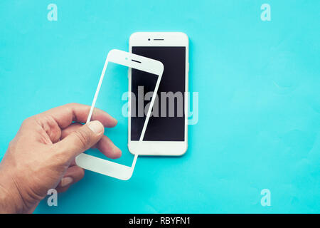Männliche hand Stick gehärtetes Glas Schild oder Film-Cover mit mobilen phone.protector Konzepte Ideen Stockfoto