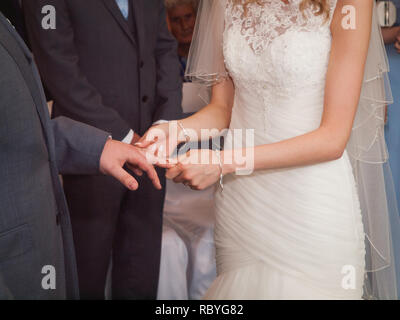 Trauringe. Hochzeitstag. Hände von Braut und Bräutigam in feierlichen Prozess des Austausches von Ringe, Symbol für die Schaffung von neuen glücklichen Familie. Stockfoto