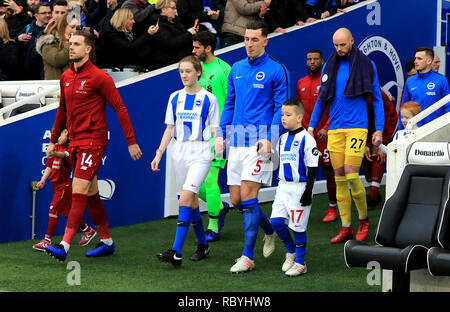 Liverpools Jordan Henderson (links) und Brighton & Hove Albion Lewis Dunk (rechts) gehen Sie aus dem Tunnel am Start der Premier League Match an der AMEX Stadion, Brighton. Stockfoto