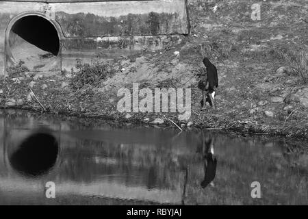 Eine zufällige Mann hinter einer Runde Düker, Schwarz & Weiß Stockfoto