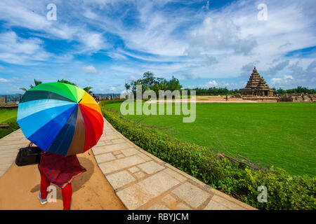 Eine Frau mit einem bunten Sonnenschirm an den Monumenten in Mahabalipuram in der Nähe von Chennai, Indien Stockfoto