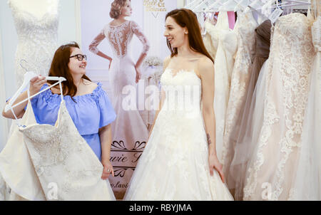 Frau in einem Hochzeitskleid Verschraubung an der Hochzeitsmesse. Präsentiert Szene mit einem Modell aus der Messestand. Essen, Nordrhein-Westfalen, Deutschland, Eur Stockfoto