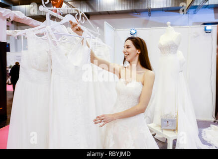 Frau in einem Hochzeitskleid Verschraubung an der Hochzeitsmesse. Präsentiert Szene mit einem Modell aus der Messestand. Essen, Nordrhein-Westfalen, Deutschland, Eur Stockfoto