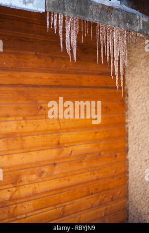 Eiszapfen am Rande eines Holzschuppen Dach Stockfoto