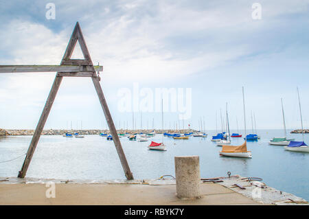 Ein vintage Holz- Thunfisch Hebezeug mit Blick auf die kleinen Segelboote im Hafen von Rockport, Massachusetts auf einem nebligen Sommer morgen günstig Stockfoto