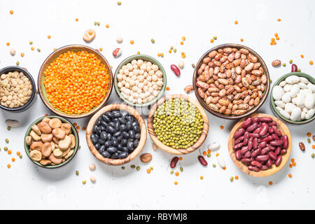 Hülsenfrüchte, Linsen, Bohnen und chikpea Sortiment in verschiedenen Schüsseln auf weißen Tisch Ansicht von oben. Stockfoto