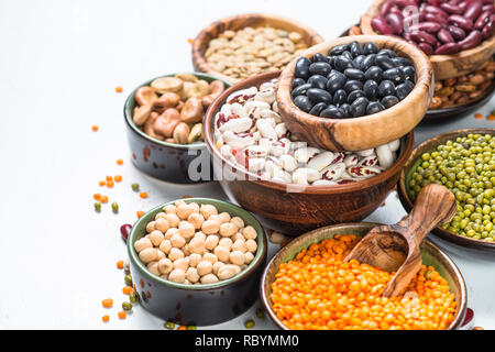 Hülsenfrüchte, Linsen, Bohnen und chikpea Sortiment in verschiedenen Schüsseln auf weißer Tisch. Stockfoto