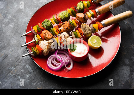 Huhn Hariyali kakab oder Malai malai Kebab serviert mit Spießen und Joghurt dip in eine Platte. selektive Fokus Stockfoto