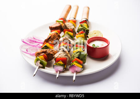 Huhn Hariyali kakab oder Malai malai Kebab serviert mit Spießen und Joghurt dip in eine Platte. selektive Fokus Stockfoto