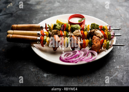 Huhn Hariyali kakab oder Malai malai Kebab serviert mit Spießen und Joghurt dip in eine Platte. selektive Fokus Stockfoto