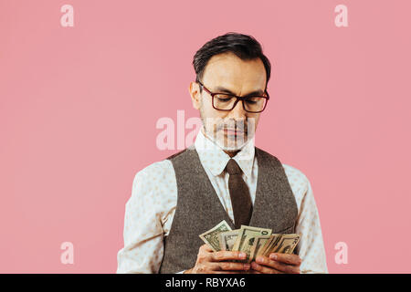 Reifer Mann zählen Geld, auf Pink Studio Hintergrund isoliert Stockfoto