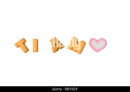 TI AMO bedeutet: Ich liebe Dich in Italienisch mit Alphabet geformte Gebäck und eine herzförmige Marshmallow candy auf weißem Hintergrund geschrieben Stockfoto