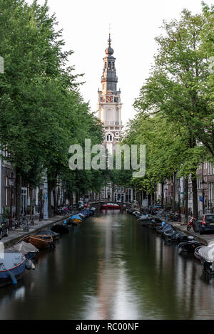 Ein Blick entlang einer Gracht in Amsterdam, in Richtung der Zuiderkerk Kirche, im Jahre 1611 erbaut und einmal von Monet gemalt. Stockfoto