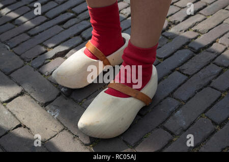 Klassische niederländische Holzschuhe durch ein Mädchen mit roten Socken Stockfoto