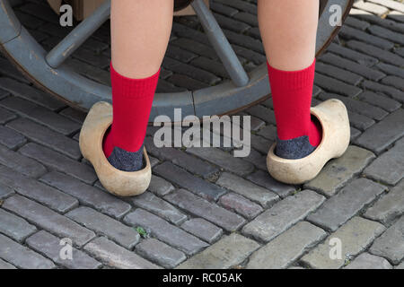 Zurück Blick auf klassische niederländische Holzschuhe durch ein Mädchen mit roten Socken Stockfoto