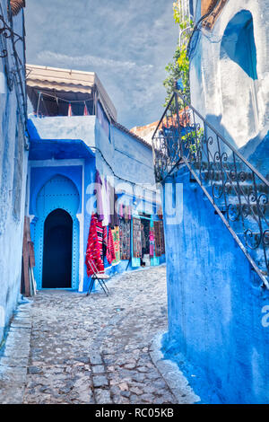 Typische Straße der Medina von Fes mit kleinen Souvenirläden, die ihre Produkte auf der Straße an. In Marokko, Nordafrika Stockfoto