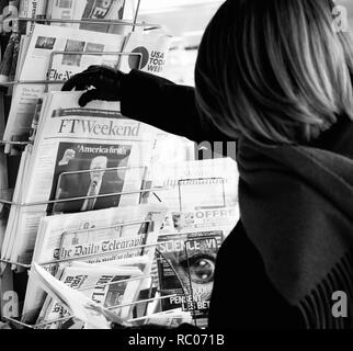 PARIS, Frankreich, 21.JANUAR 2017: Frau kaufen FT Wochenende Zeitung bei Presse Kiosk mit Donald Trump US-Präsident Amerikas erste Slogan Stockfoto