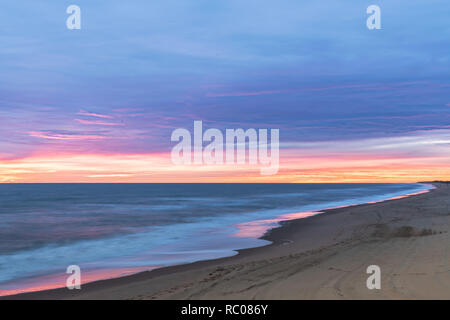Sunrise entlang des Atlantischen Ozeans in Virginia Beach in Little Island Park in Sandbridge. Die Sonne schafft Rosa und Lila pastell Reflexionen auf dem Sur Stockfoto