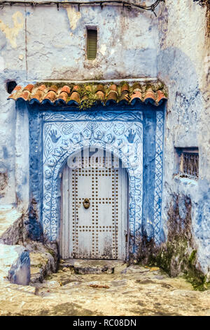 Fassade eines alten Hauses mit einer großen hölzernen Tor, in Chaouen, Marokko Stockfoto