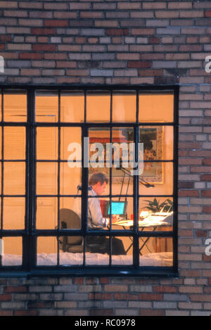 Mann bei der Arbeit spät in high-rise apartment Home Office, NYC, USA Stockfoto