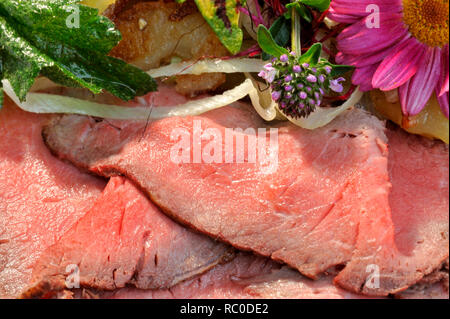 Roastbeef mit Bratkartoffeln, dekoriert mit essbaren Sky und Kräutern | Roastbeef mit Braten oder Bratkartoffeln Stockfoto