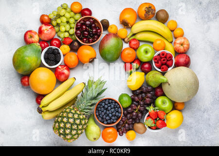 Herz aus gesunden bunten Früchten, Pflaumen Erdbeeren Himbeeren Orangen, Äpfel, Kiwis, Weintrauben, Heidelbeeren mango Kaki Ananas auf Weiß Stockfoto