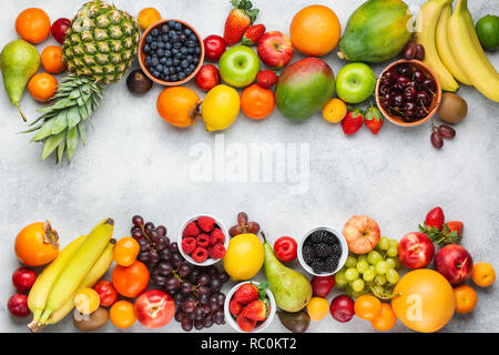 Gesunde Früchte Beeren Hintergrund Pflaumen Erdbeeren Himbeeren, Orangen, Äpfel, Kiwis, Weintrauben, Heidelbeeren mango Kaki am weißen Tisch Stockfoto