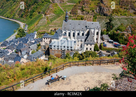 Touristen genießen den Blick auf das Dorf Beilstein an der Mosel mit Klosterkirche die St. Joseph's und die umliegenden Weinberge. Deutschland. Stockfoto