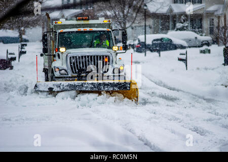 Weisse Truck mit orangefarbenen Warnleuchten Yellow Snow Plow blade Antriebe durch Straßen clearing frisch gefallenen Schnee im Winter Stockfoto