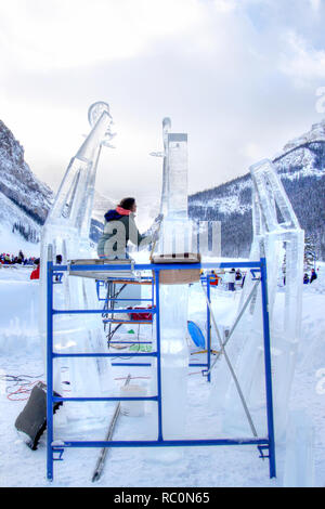 LAKE LOUISE, KANADA - Jan 22, 2011: Ein Eis Bildhauer schnitzt Ein grosser Eisblock mit einem schnitzen Werkzeug während der jährlichen Eis Magie Festival in der Ca statt Stockfoto