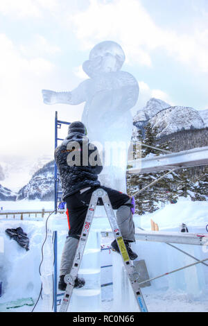 LAKE LOUISE, KANADA - Jan 22, 2011: Ein Eis Bildhauer schnitzt Ein grosser Eisblock mit einem schnitzen Werkzeug während der jährlichen Eis Magie Festival in der Ca statt Stockfoto