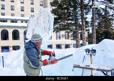 LAKE LOUISE, KANADA - Jan 22, 2011: Ein Eis Bildhauer schnitzt Ein grosser Eisblock mit einem Power Tool während der jährlichen Eis Magie Festival in der Kana gehalten Stockfoto