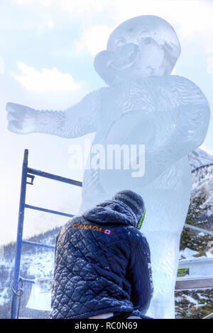 LAKE LOUISE, KANADA - Jan 22, 2011: Ein Eis Bildhauer schnitzt Ein grosser Eisblock mit einem schnitzen Werkzeug während der jährlichen Eis Magie Festival in der Ca statt Stockfoto