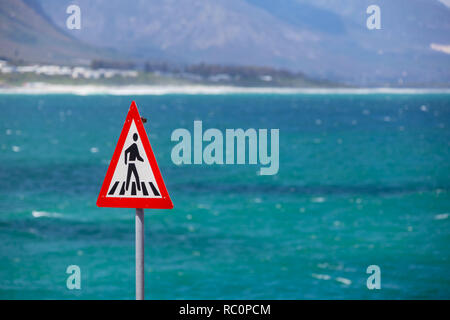 Fußgängerüberweg Zeichen und das blaue Meer im Hintergrund Stockfoto