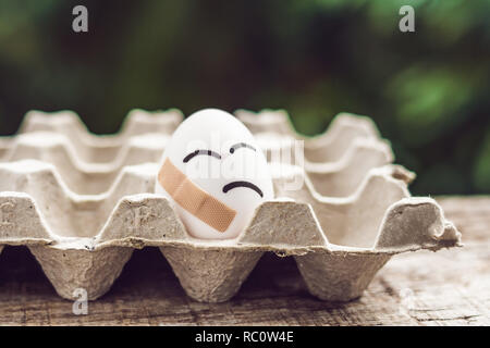 Gebrochene Eier mit Pflaster. Konzept der Sprödigkeit und Schmerzen. Stockfoto