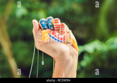 Die USA hand drückt auf die Nordkoreanischen Ei. Konflikt zwischen den Vereinigten Staaten und Nordkorea. Stockfoto