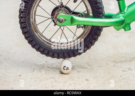 Ei - Calcium, unter der schweren Rad eines Fahrrades nicht brechen. Die Macht der Infinitesimalrechnung Konzept. Stockfoto