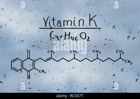 Strukturelle Modell von Vitamin K auf dem Glas mit Regentropfen. Stockfoto