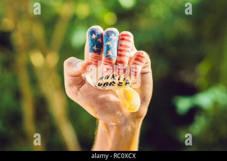 Die USA hand drückt auf die Nordkoreanischen Ei. Konflikt zwischen den Vereinigten Staaten und Nordkorea. Stockfoto