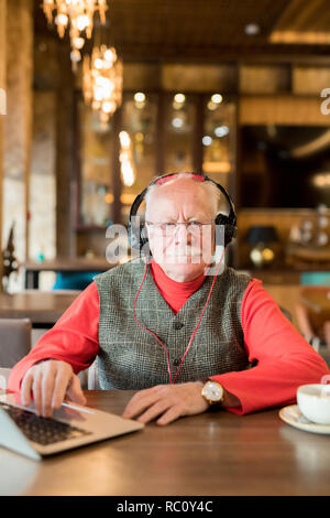 Älterer Mann mit Schnurrbart mit Laptop Stockfoto