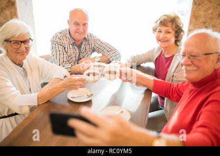 Fröhliche Senioren zusammen Fotografieren, während sie Tee trinken. Stockfoto