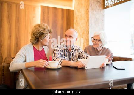 Schöner Mann im Gespräch mit älteren Damen Stockfoto