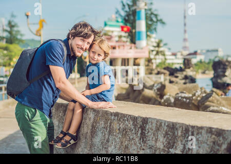 Vater und Sohn Reisende im Hintergrund Dinh Cau Leuchtturm Symbol der Insel Phu Quoc, Vietnam. Phu Quoc ist ein vietnamesisches Insel vor der Küste o Stockfoto