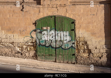 Alte verwitterte grün Garagentor in einer Straße in Silema, Malta. Stockfoto