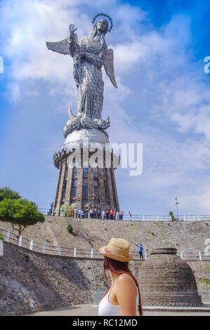 Quito, Ecuador, 12. Dezember 2018: Nicht identifizierte Frau vor La Virgin del Panecillo in einem wunderschönen blauen Himmel Stockfoto